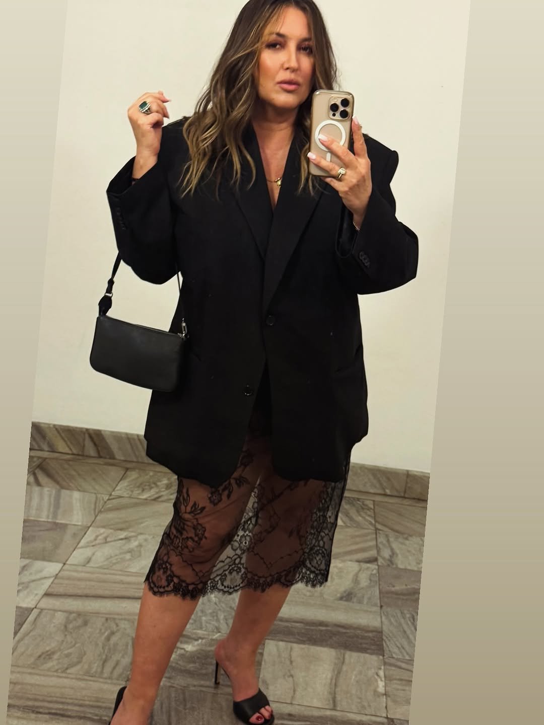 Karolina Szostak w czarnej marynarce i koronkowej spódnicy