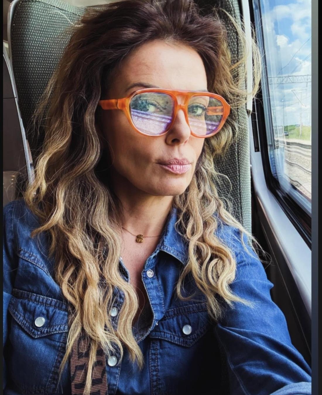 katarzyna glinka w blond lokach, na twarzy okulary z pomarańczowymi oprawkami