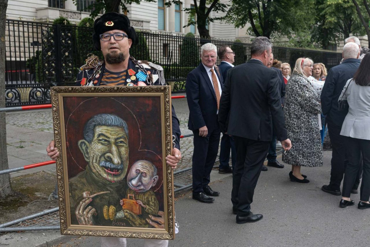  po prawo Simon Skrepetski trzymający obraz, w tle grupka mężczyzn