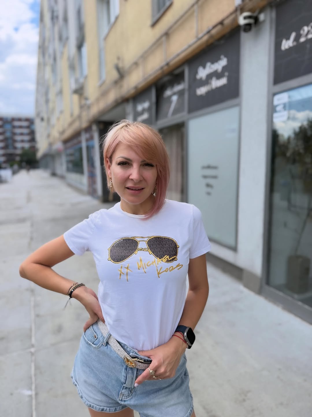 Magdalena Narożna w koszulce z grafiką pozuje na tle budynku