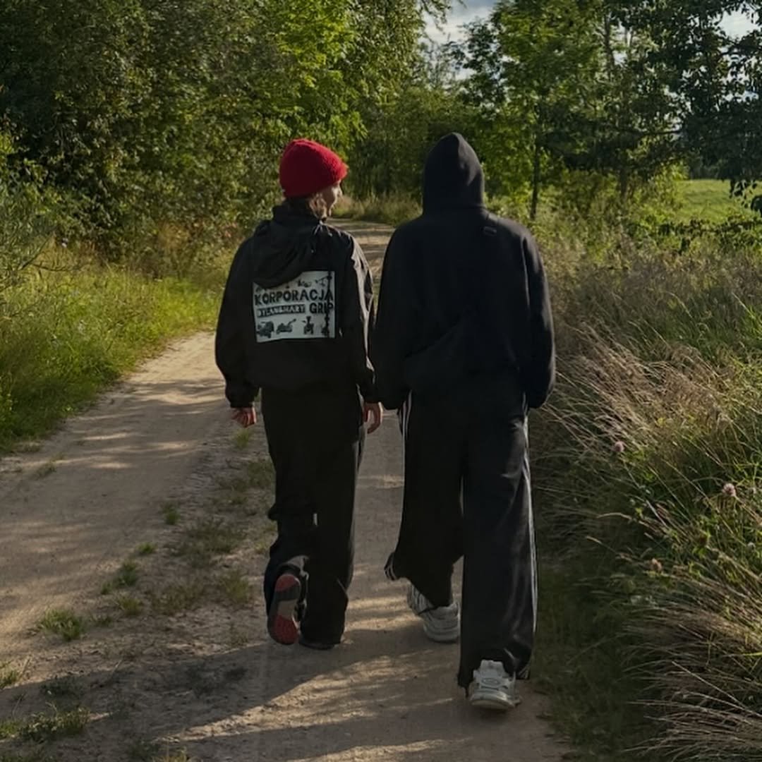 dzieci mai ostaszewskiej idą polną drogą, mają na sobie czarne dresy