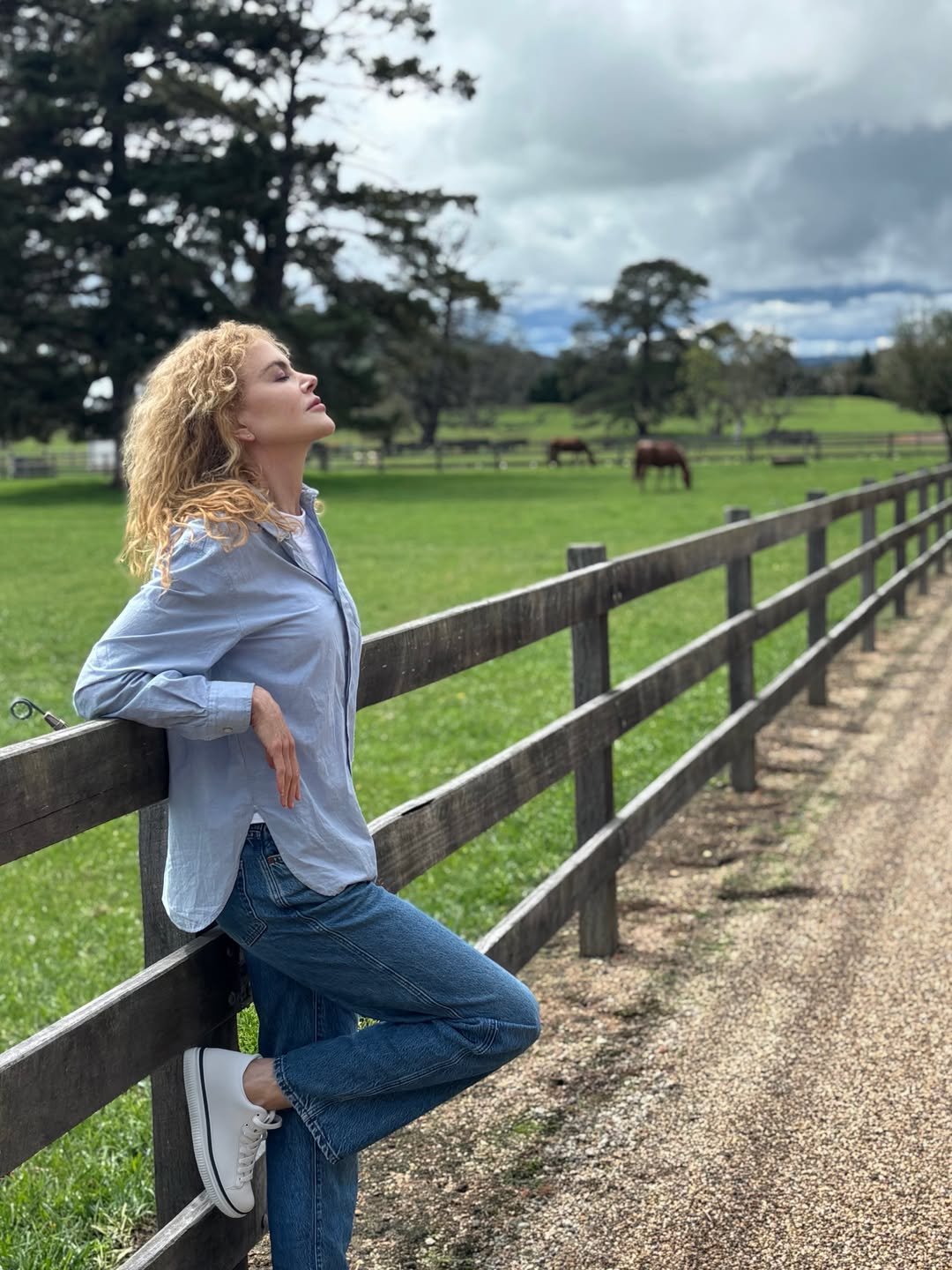 nicole kidman w rozpuszczonych włosach opiera się o drewniany płot