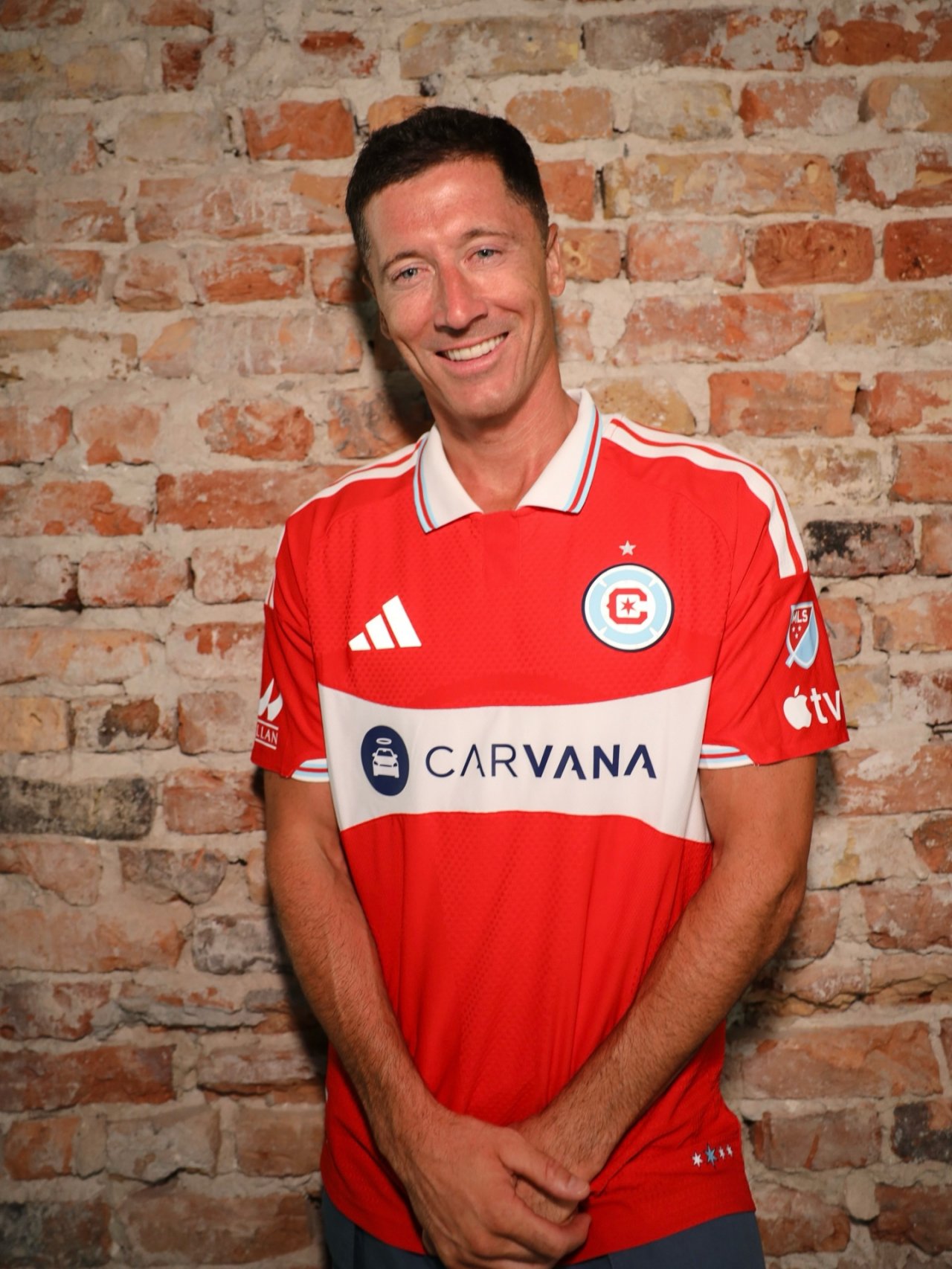 Robert Lewandowski na tle ceglastej ściany