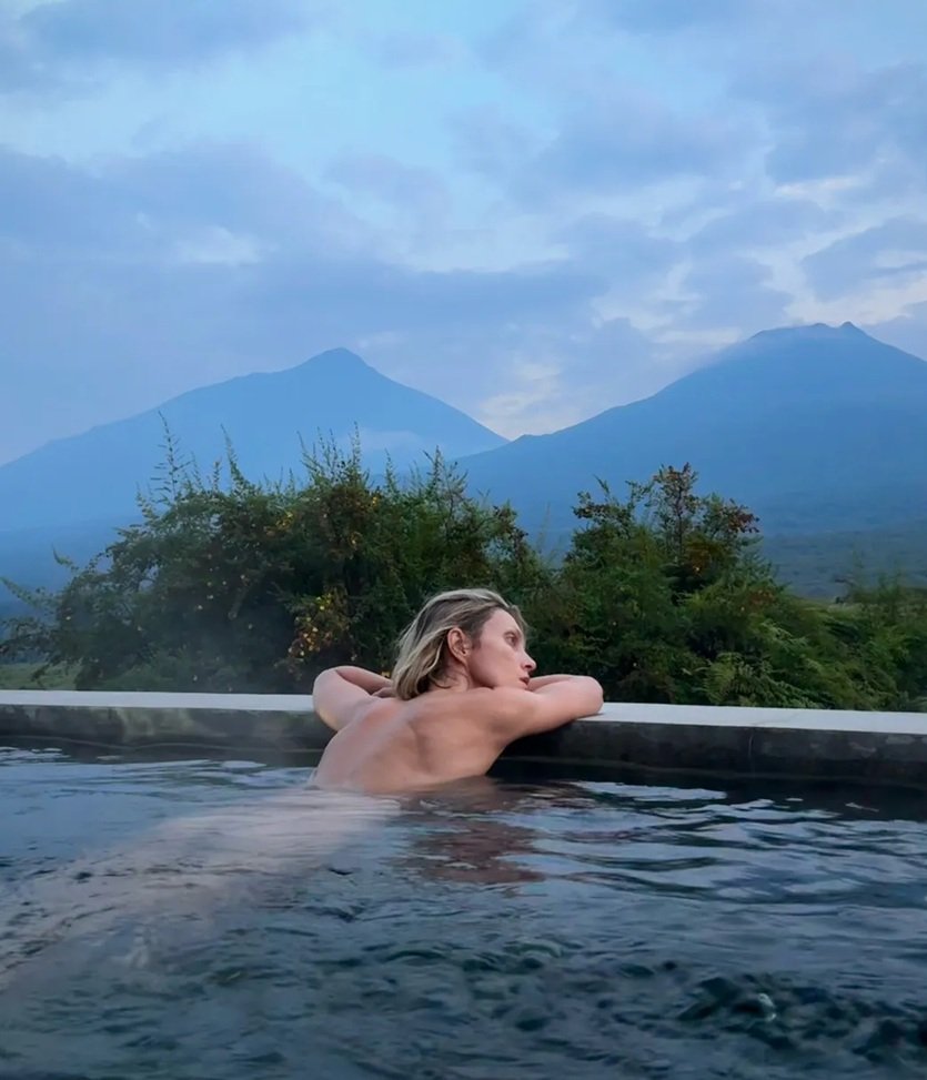Anja Rubik topless w basenie, w tle góry