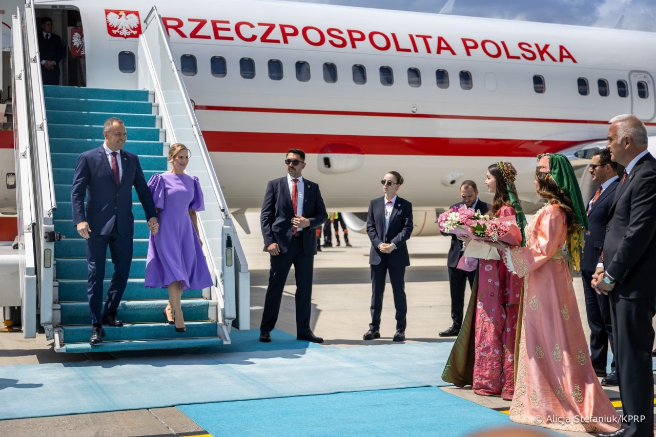 Marta Nawrocka i Karol Nawrocki wysiadają z samolotu, obok maszyny czekające kobiety i ochorna