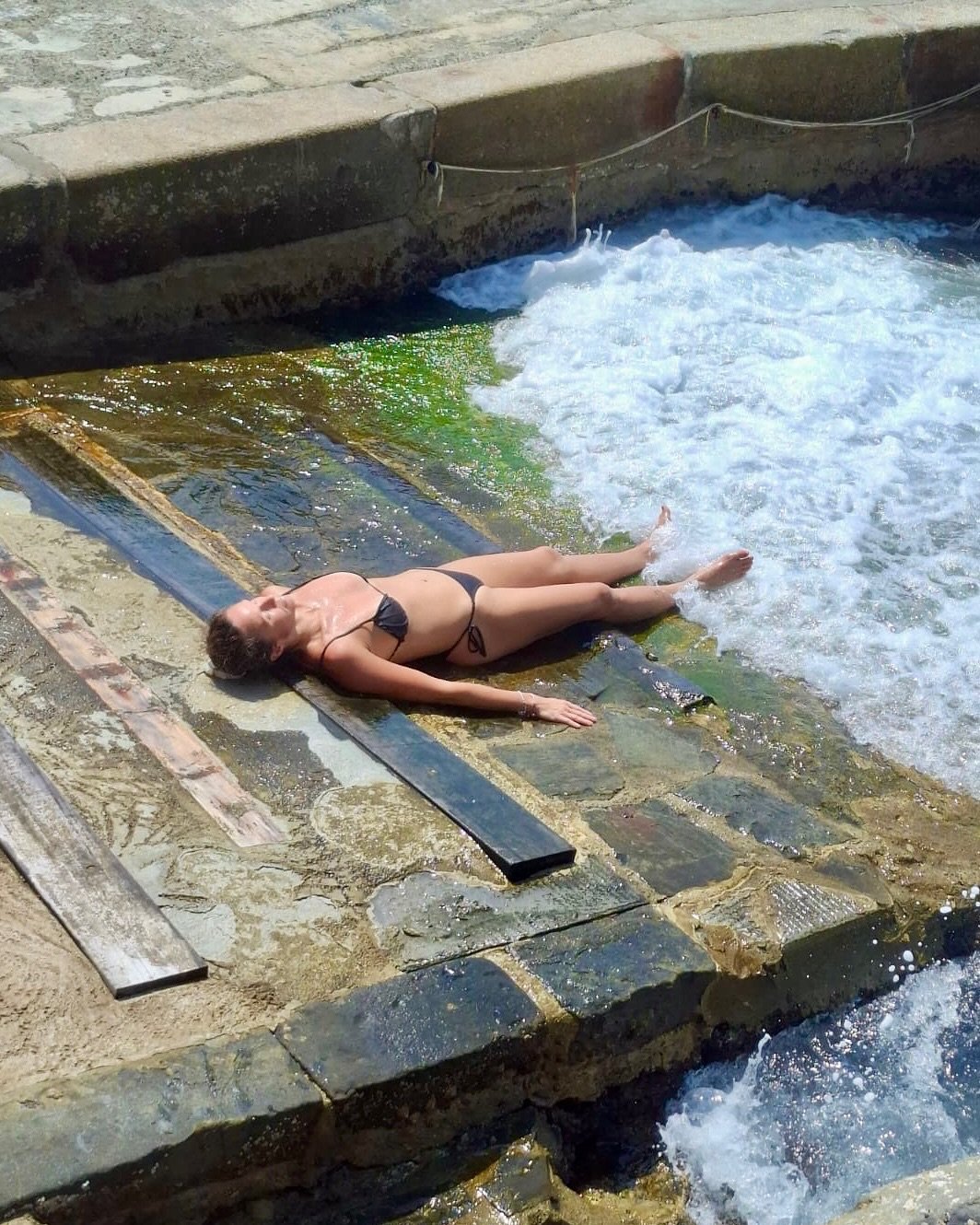 monika mrozowska w bikini leży na betonowych schodach