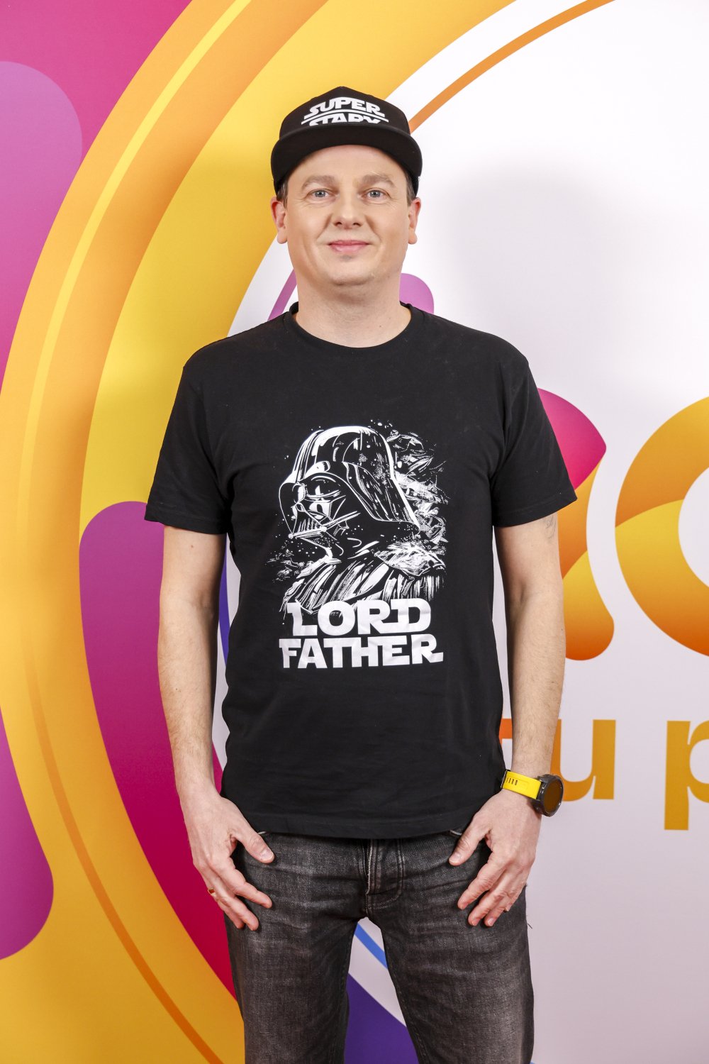 tomasz bajer w czarnym stroju z czapką z daszkiem