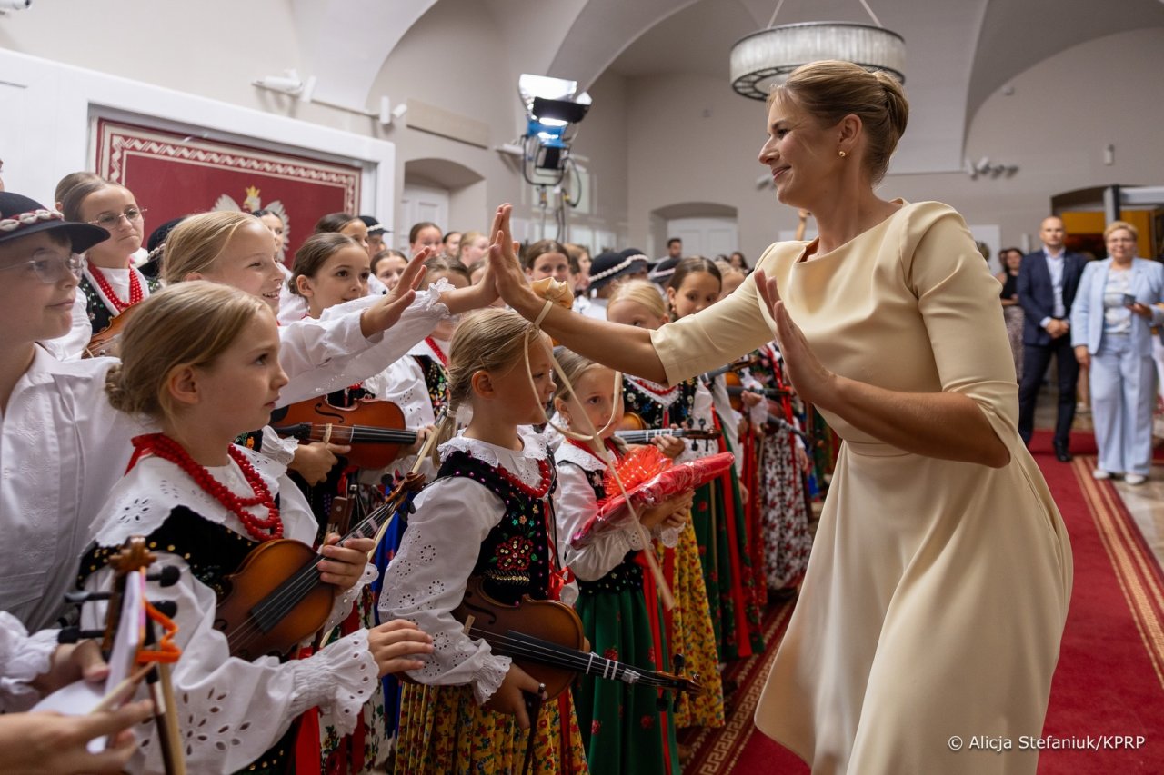 marta nawrocka wśród dziec ubranych w ludowe stroje