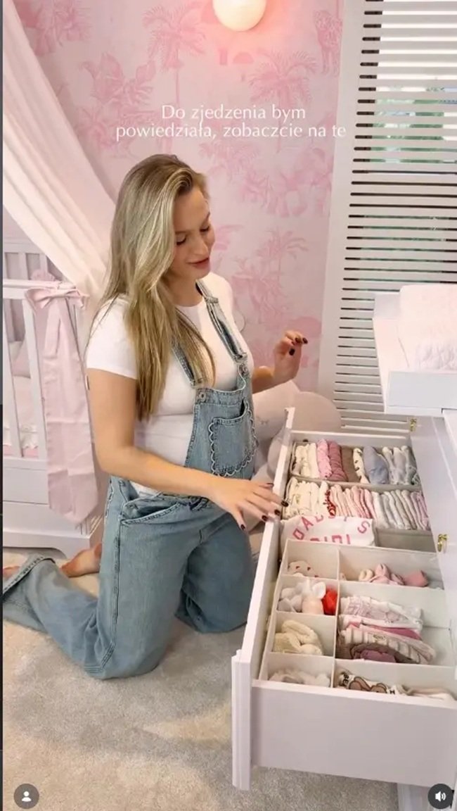 karolina pisarek klęczy przy szufladzie z niemowlęcymi ubrankami