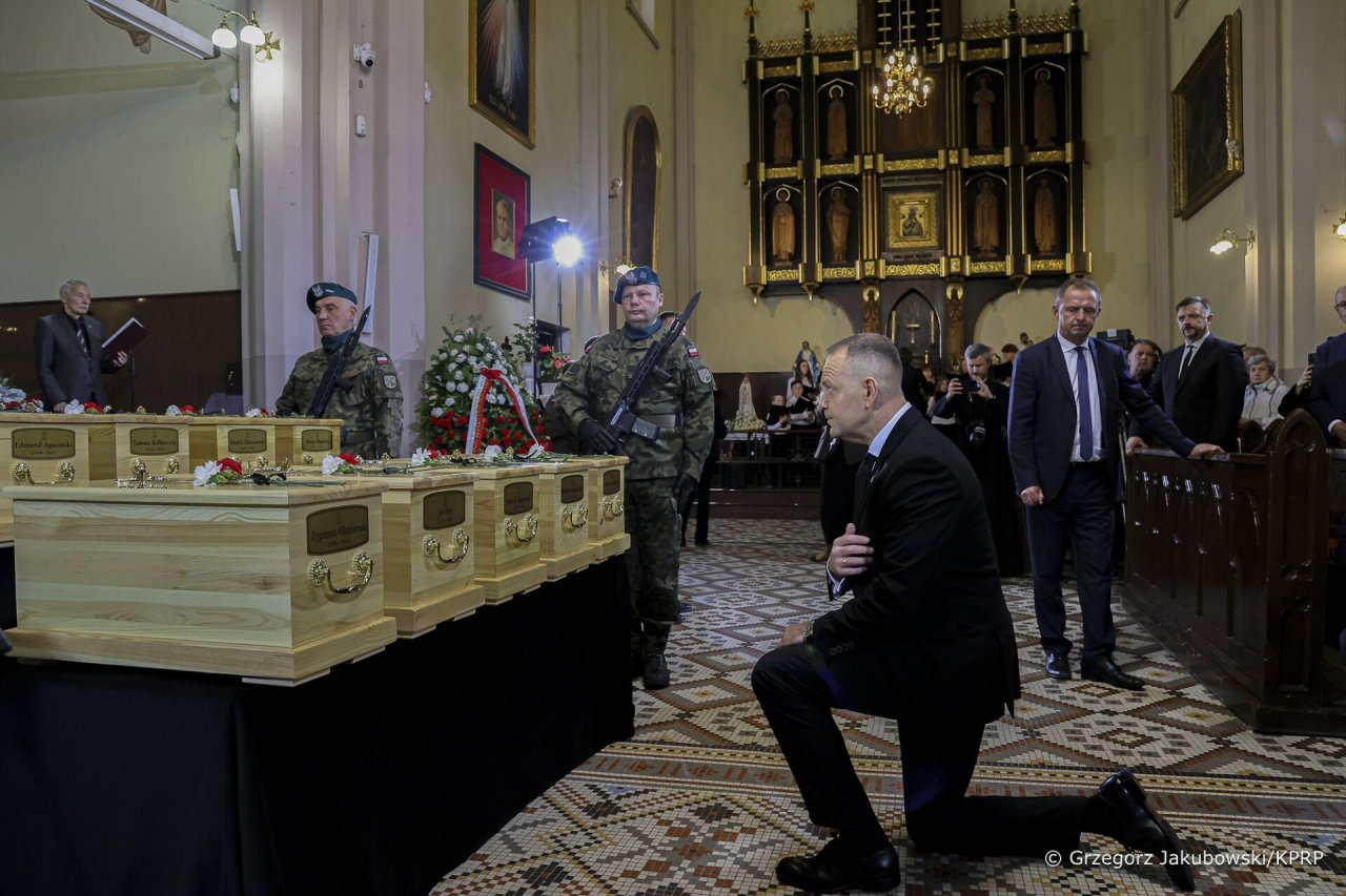 karol nawrocki klęczy przed małymi trumnami