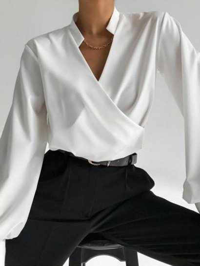 Elegancka stylizacja - biała koszula zestawiona z czarnymi spodniami w kant. Dobre rozwiązanie na formalne wyjścia!
