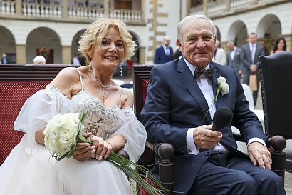 Jej mąż na tę okazję wybrał granatowy garnitur, który idealnie dopasował się do beżowej sukni żony.
