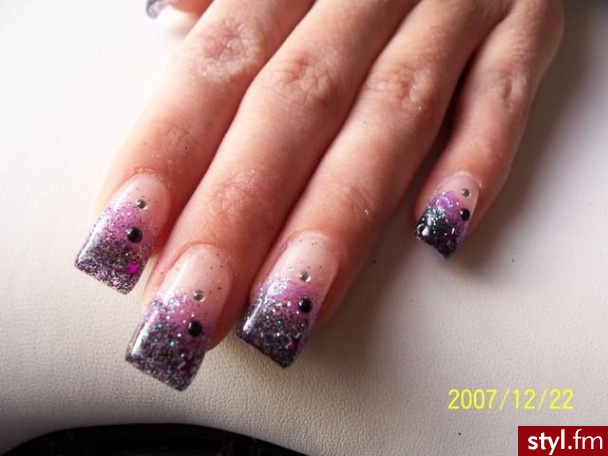 na paznokciu pasek czarnego brokatu pod nim fioletowego a na tym 3 cyrkonie fioletowa gwiazdka czarna cyrkonia mala srebrna - Paznokcie