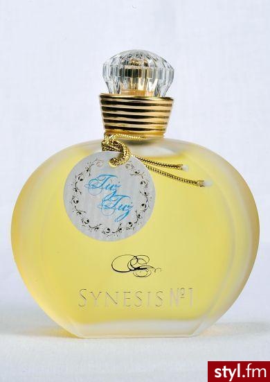 Prezentowany zapach „Tuż - Tuż” pochodzi z perfumeryjnej kolekcji kosmetycznej marki Synesis No1. 
Nuta głowy: bergamotka z Kalabrii, śliwka, ylang-ylang, pieprz, porzeczki, anyż.
Nuta serca: kwiat pomarańczy, jaśmin z Egiptu, tuberoza, róża, konwalia, - Misz-masz